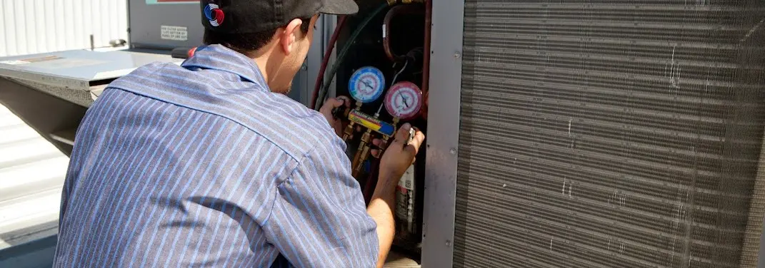 HVAC technician servicing a condenser unit in Hickory