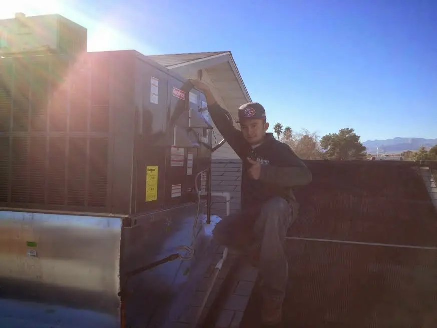 HVAC technician performing Boiler Repair on a rooftop unit in Hickory